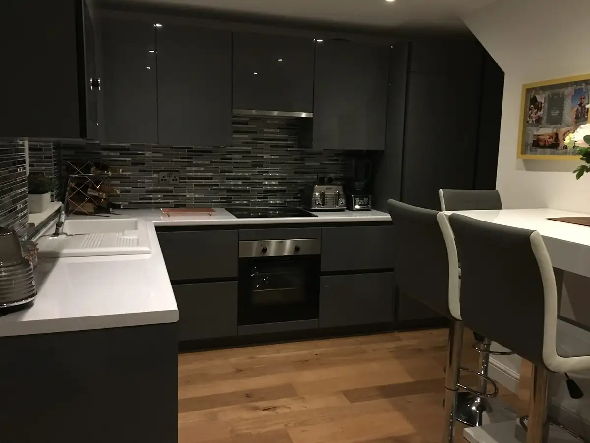 Black kitchen with patterned splashback