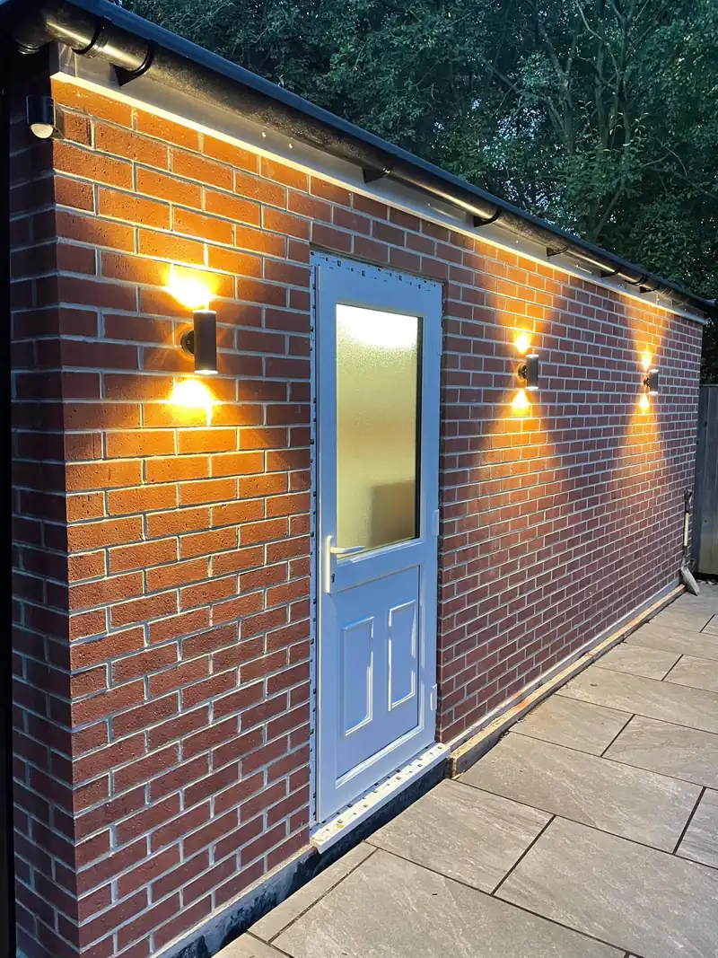 Brick extension with wall lights at night