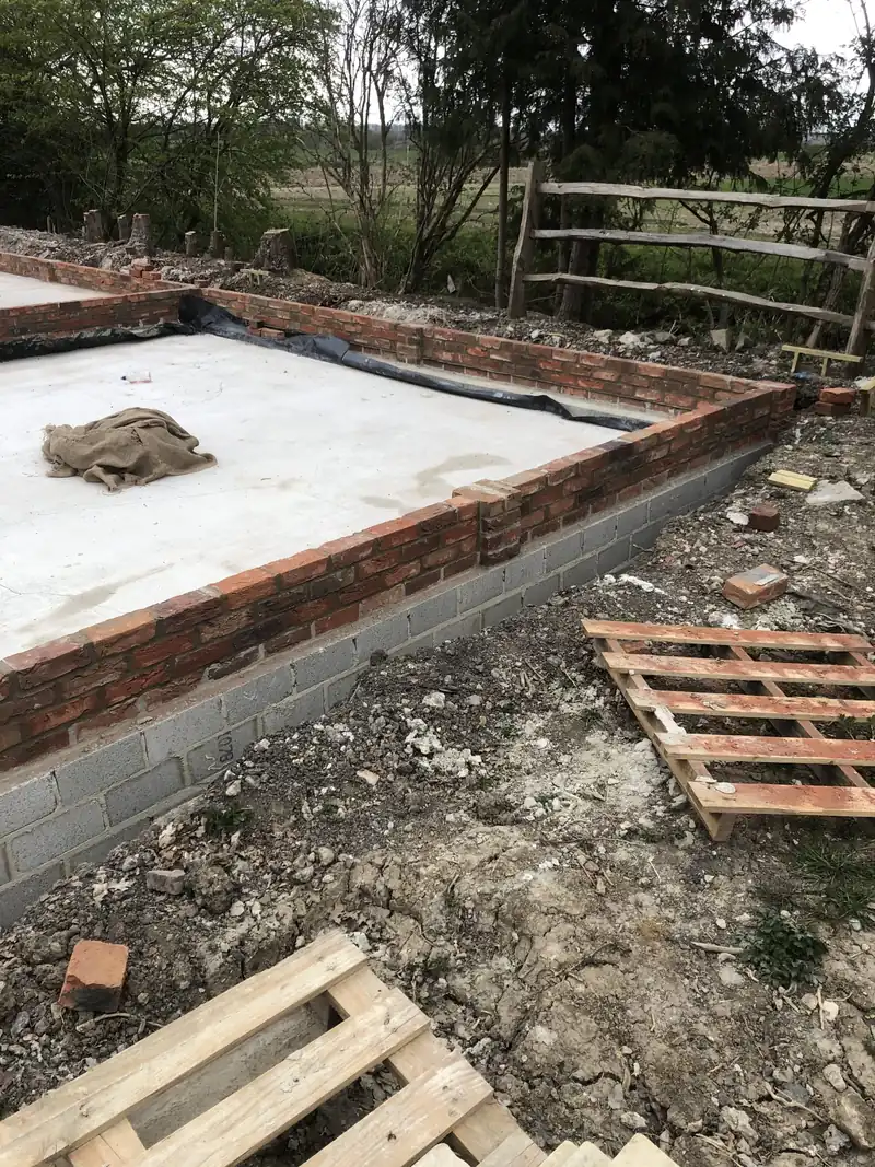 Concrete slab and upstand for a SIP building