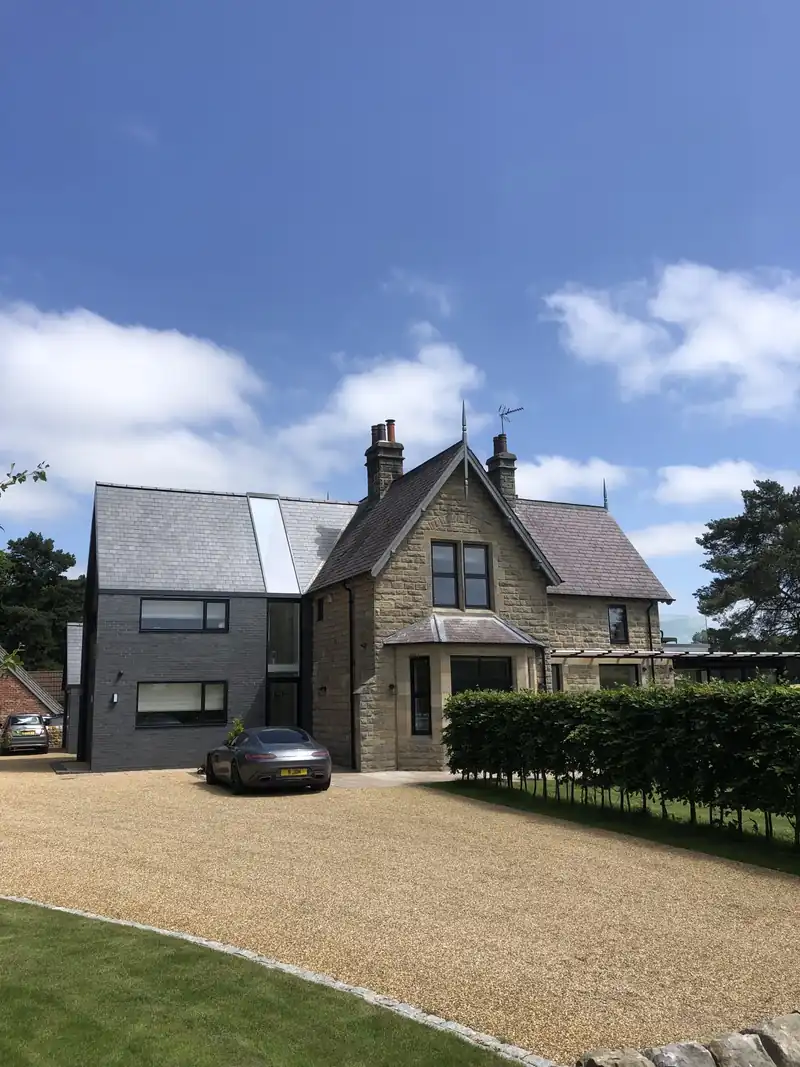 Contemporary extension beside a stone house