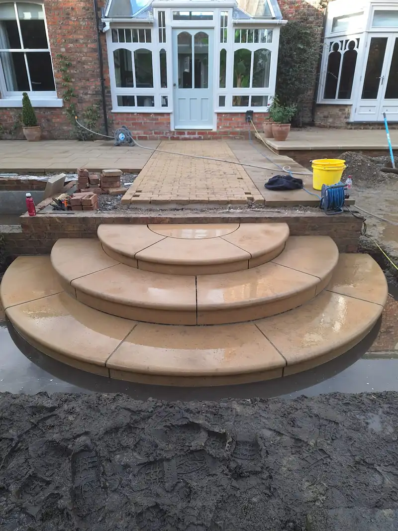 Curved sandstone steps to French doors