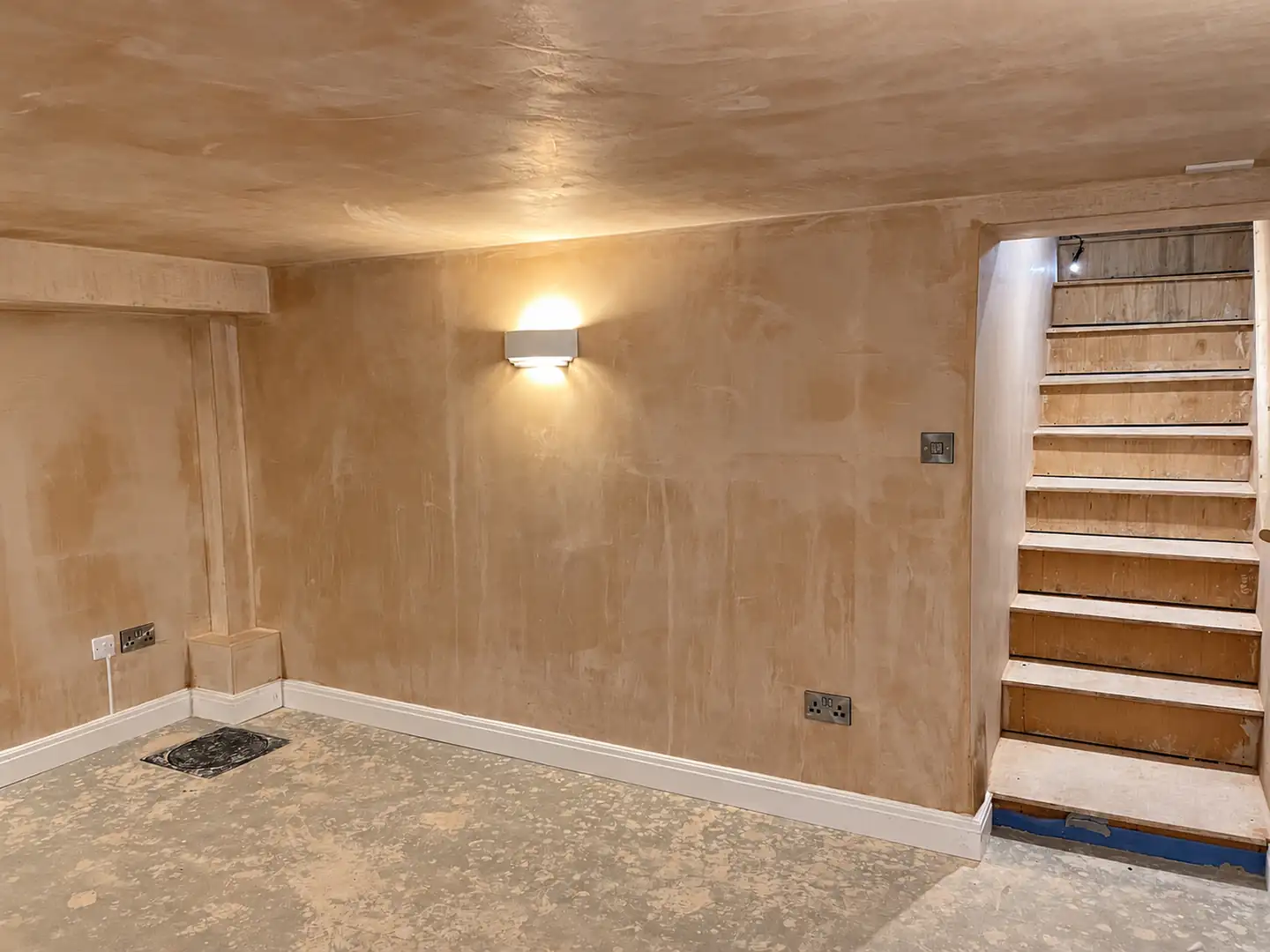 Freshly plastered room with a timber staircase