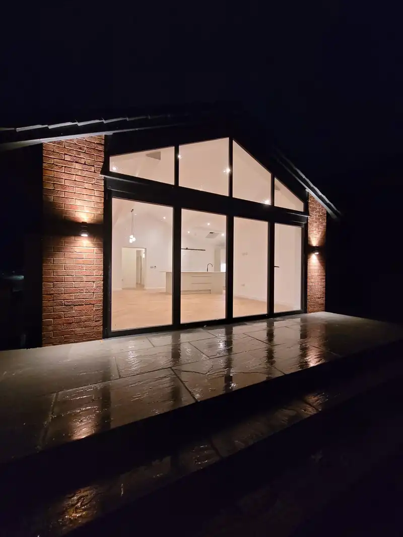 Glazed gable lit at night at Mallorie Court