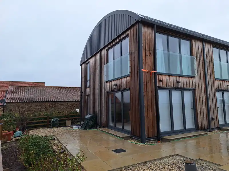 Glazed gable of the timber clad Dutch barn house at Whenby