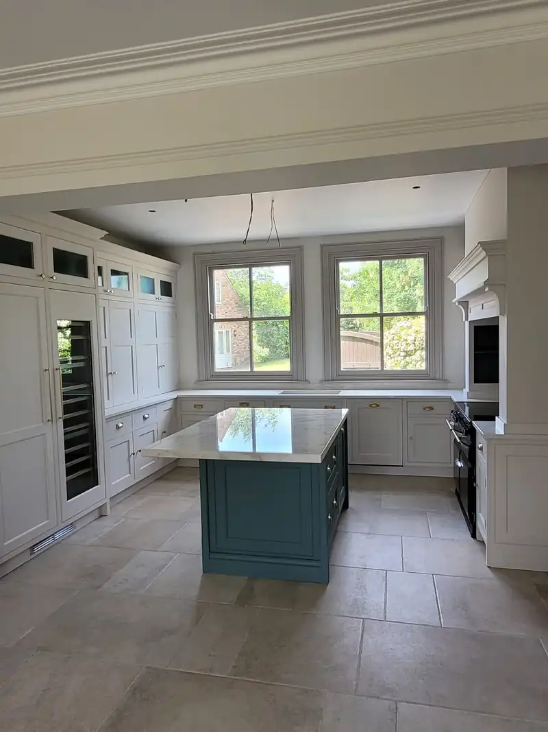 Kitchen with an island under a pair of sash windows