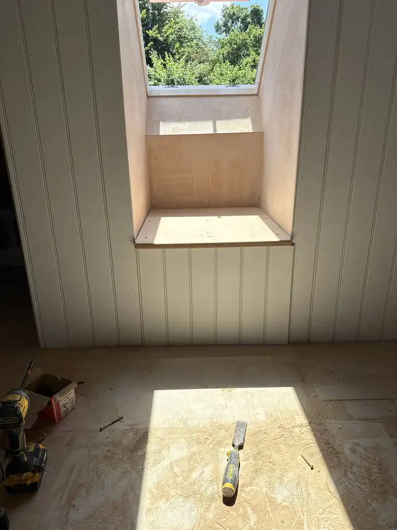 Loft room with panelled walls and a dormer window
