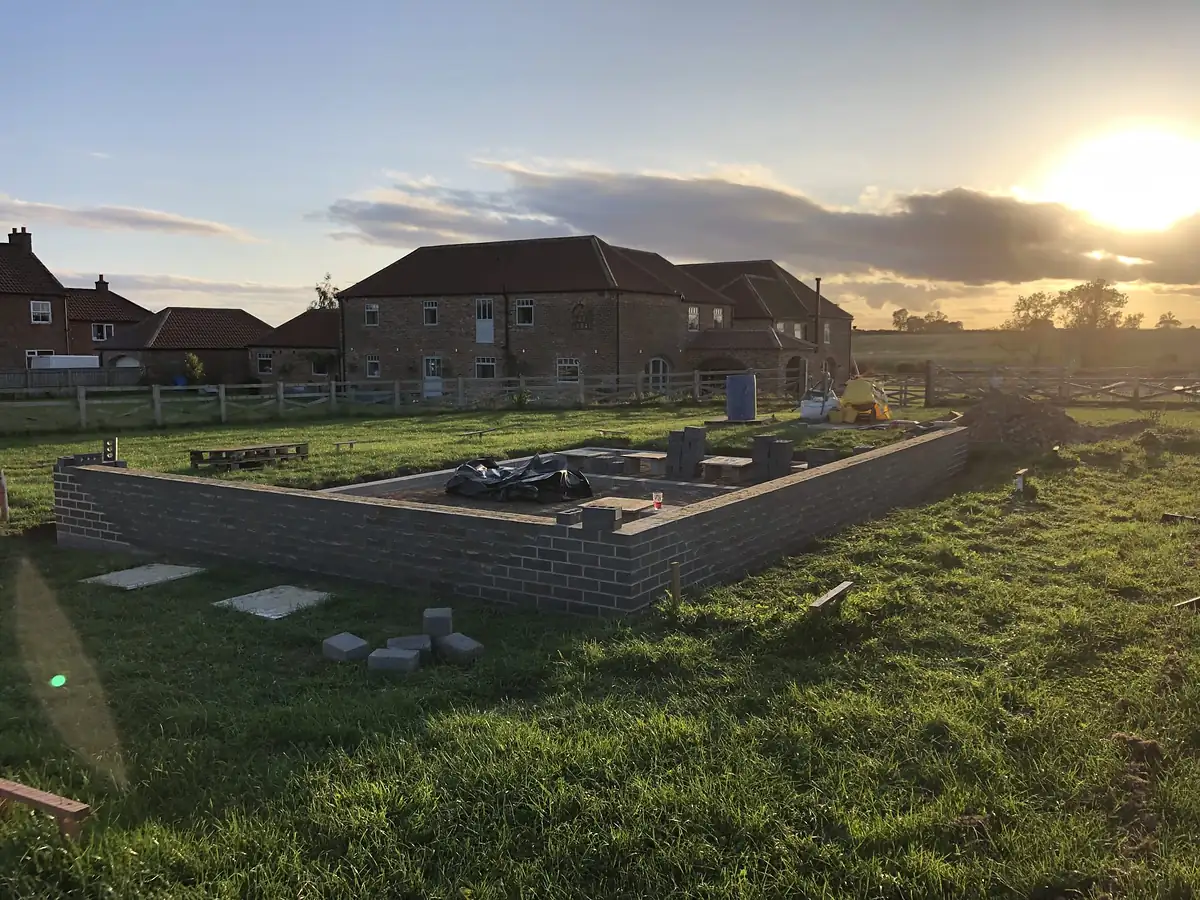 New build walls rising at sunset