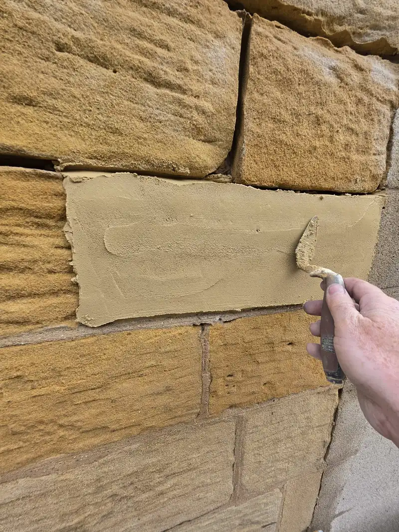 New stone face being set into an old wall