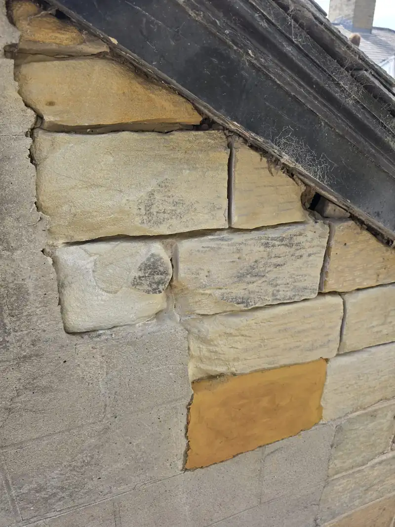 New stone faces cut into an old sandstone gable