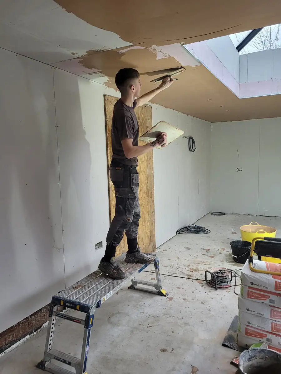Plasterer skimming a ceiling