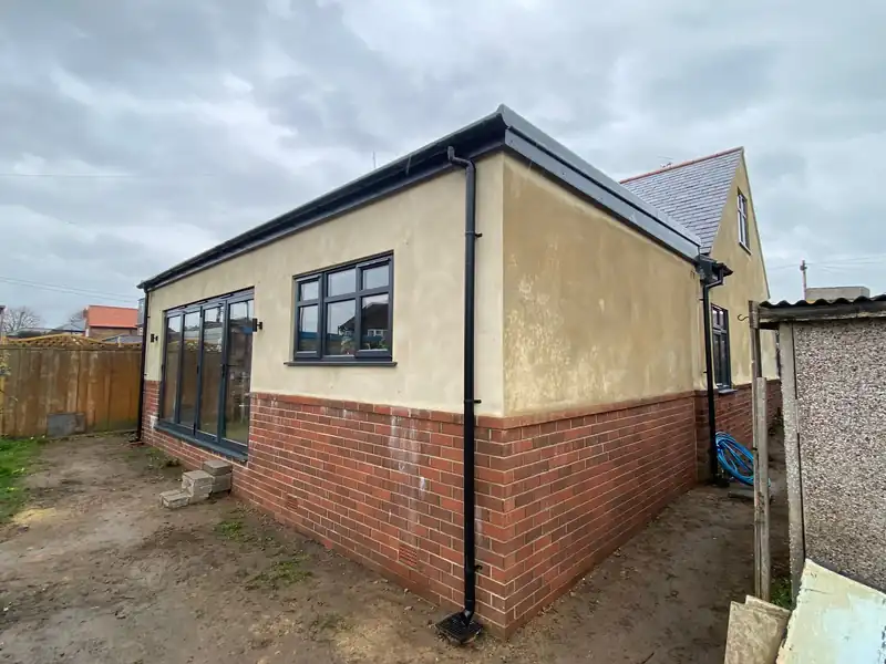 Rendered bungalow extension on a brick base