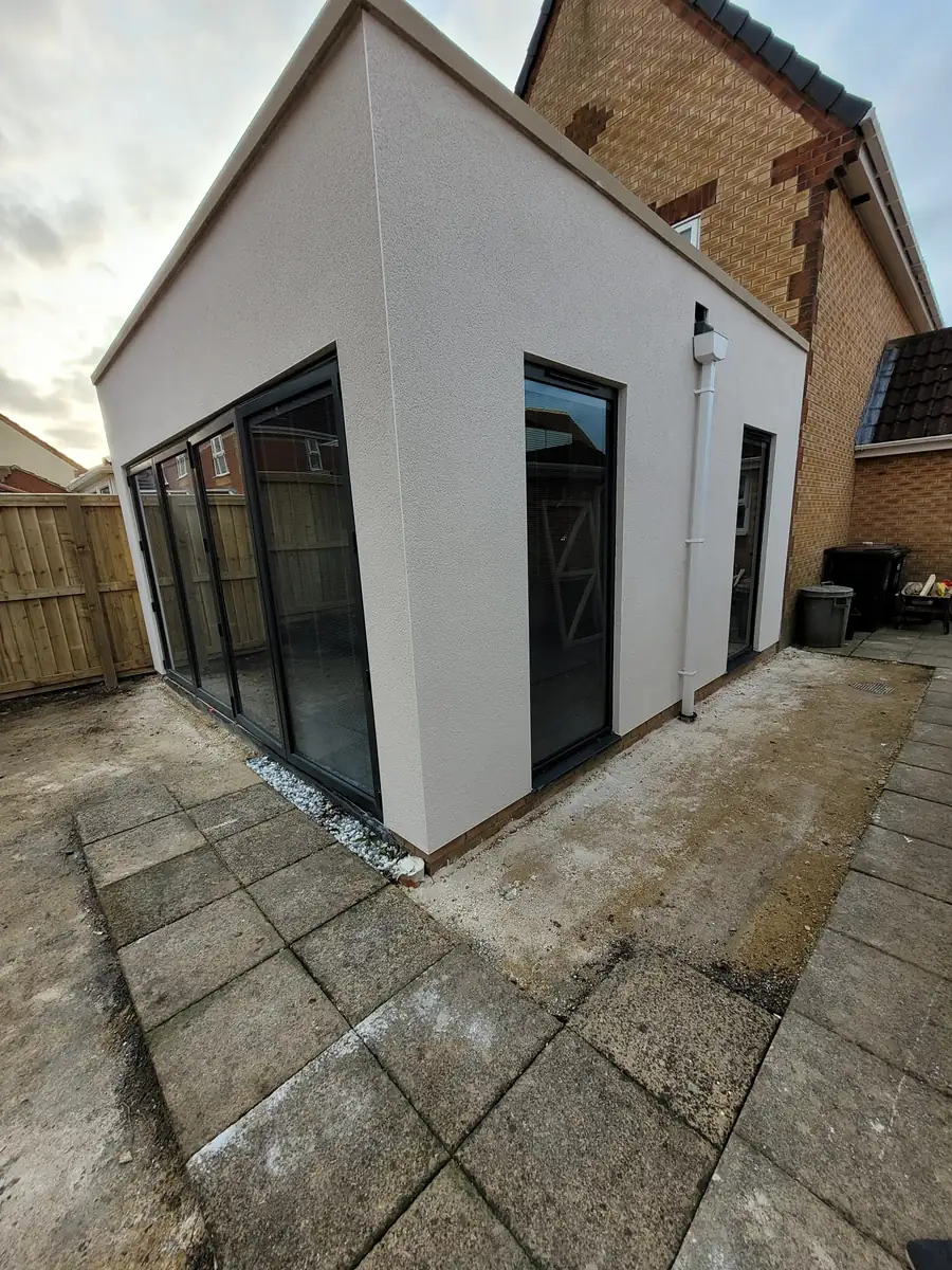 Rendered single storey extension with a slab patio