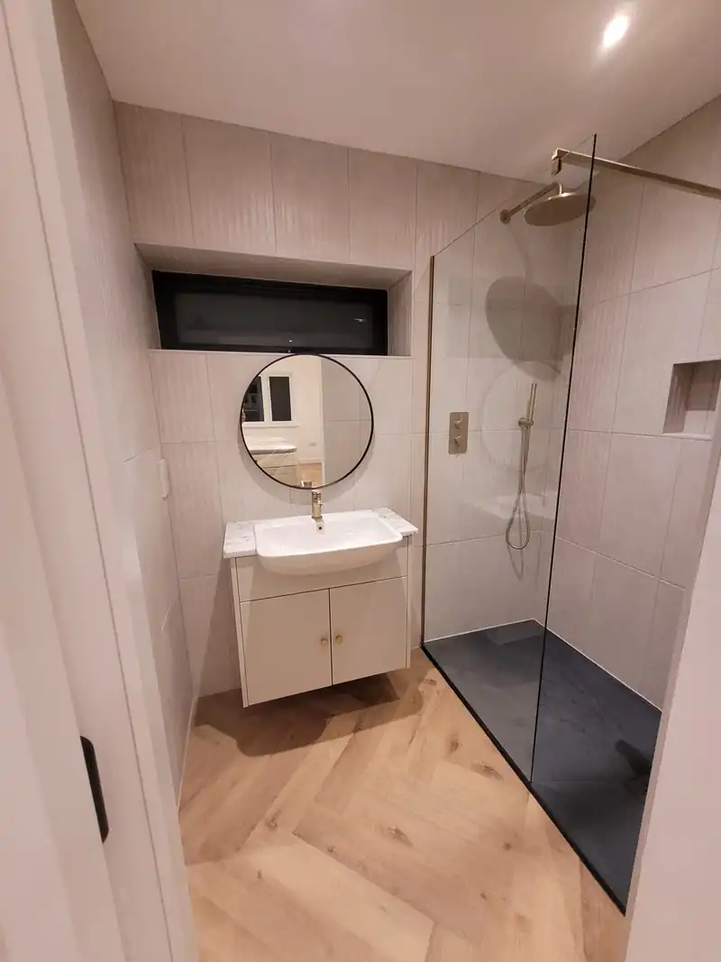 Shower room with a round mirror at Mallorie Court