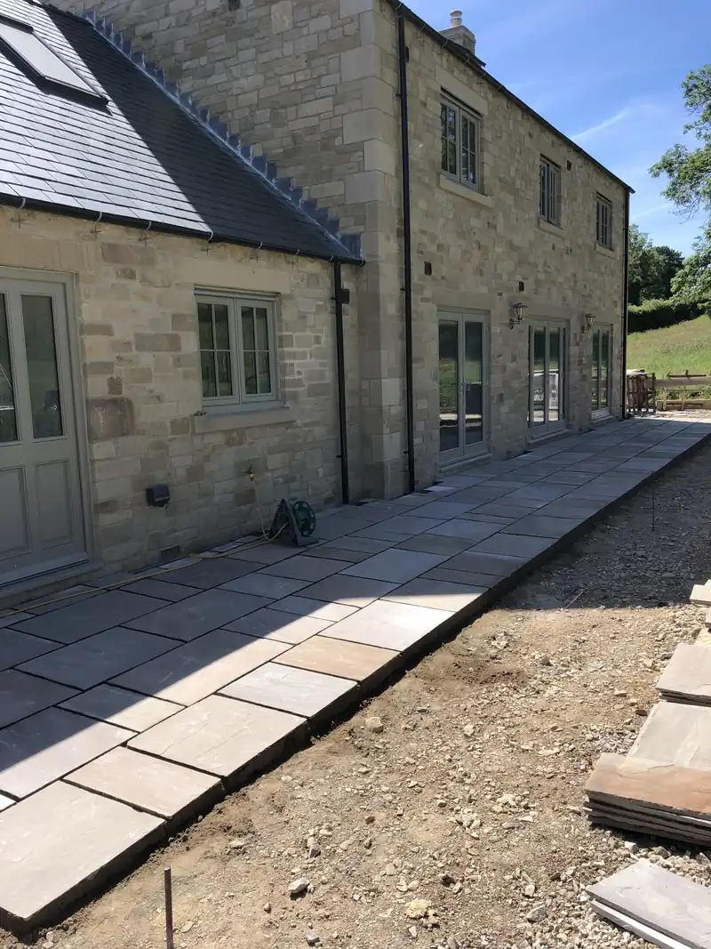 Stone new build with sandstone paving