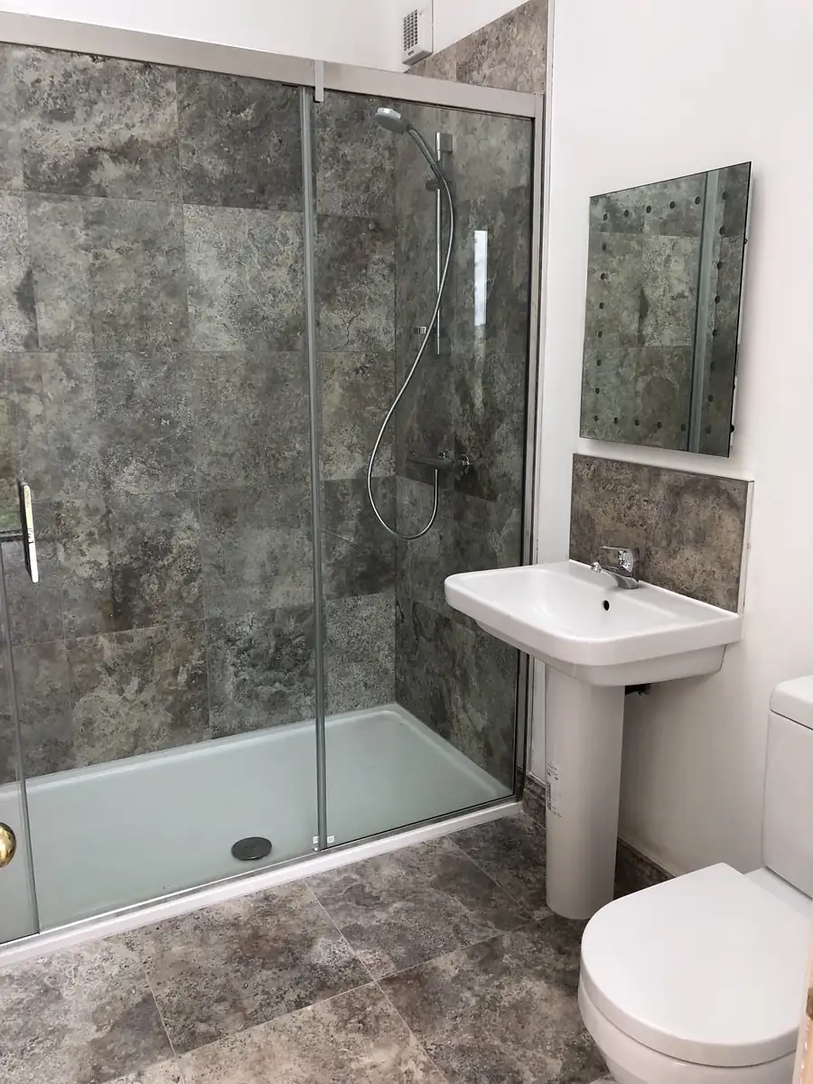 Stone tiled shower with glass screen