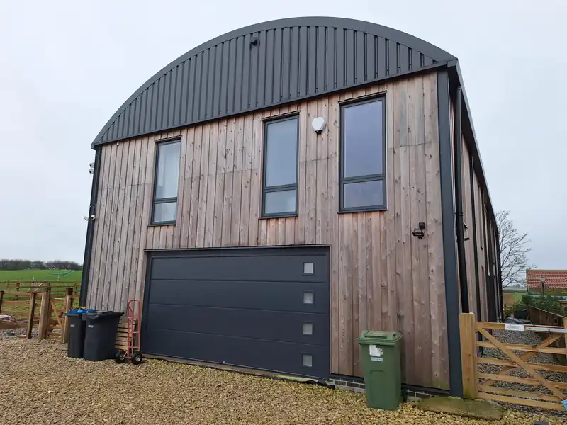 Timber clad Dutch barn house at Whenby with a curved roof